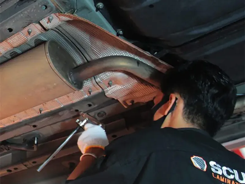 Teknisi Scuto mengaplikasikan Rust Protection di kolong mobil